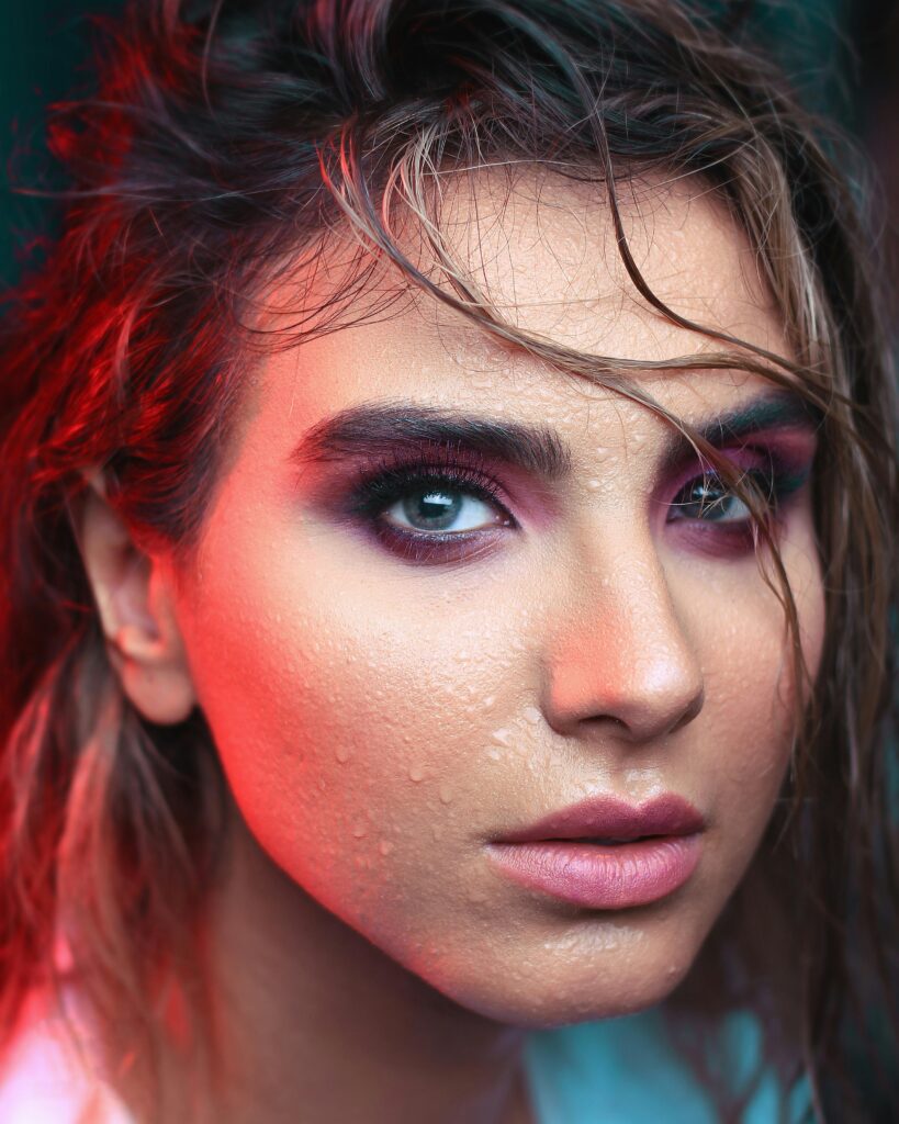 Stunning portrait featuring creative makeup with bold colors and dramatic light effects.